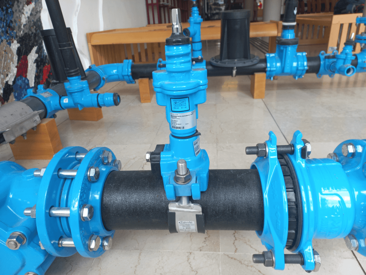 Blaues Rohrleitungsventil im Innenbereich, Teil eines komplexen Wassersystems. Ideal für industrielle Anwendungen.