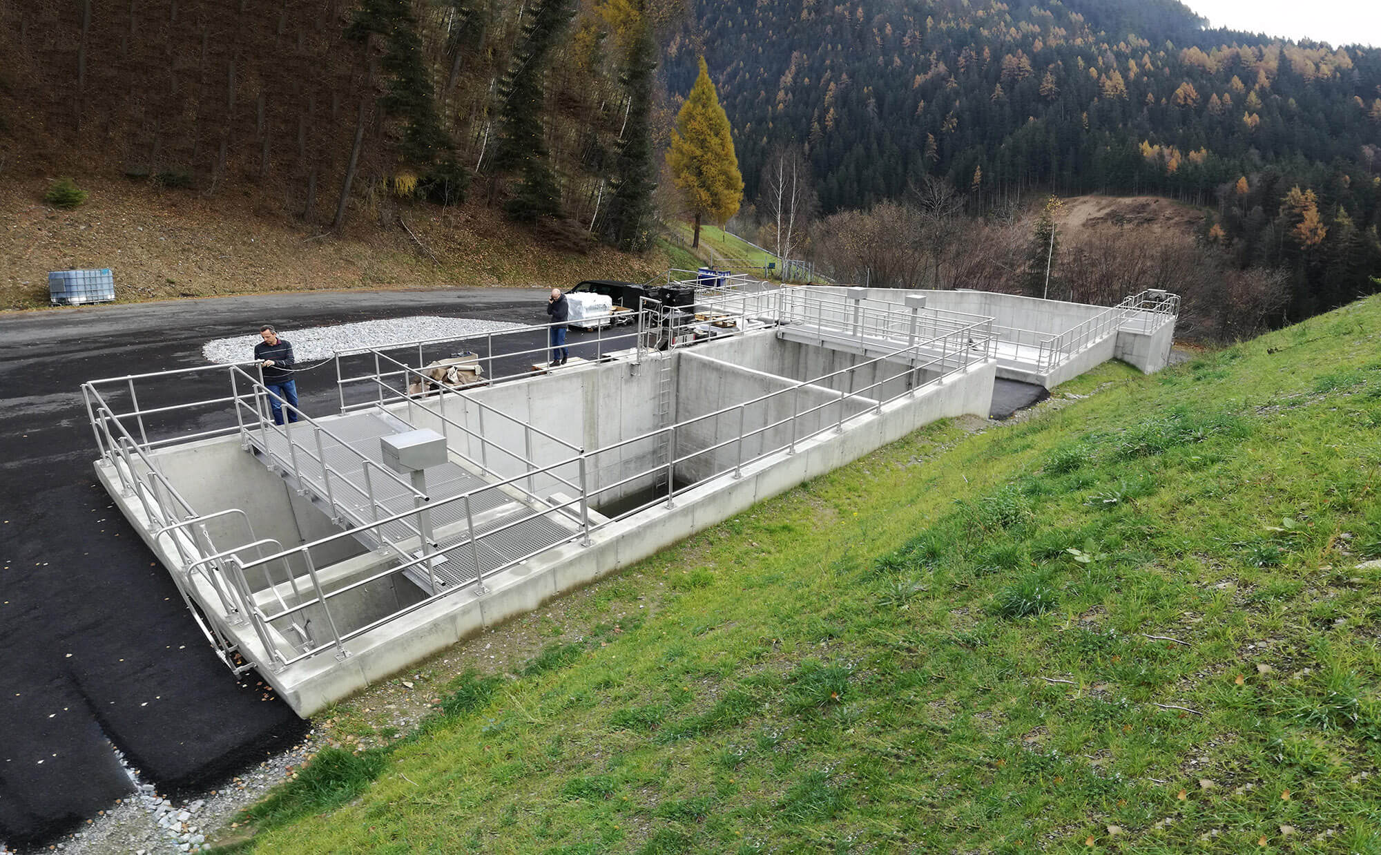 Abwasserbehandlungsanlage in bewaldeter Berglandschaft mit Blick auf den modernen Klärbereich.