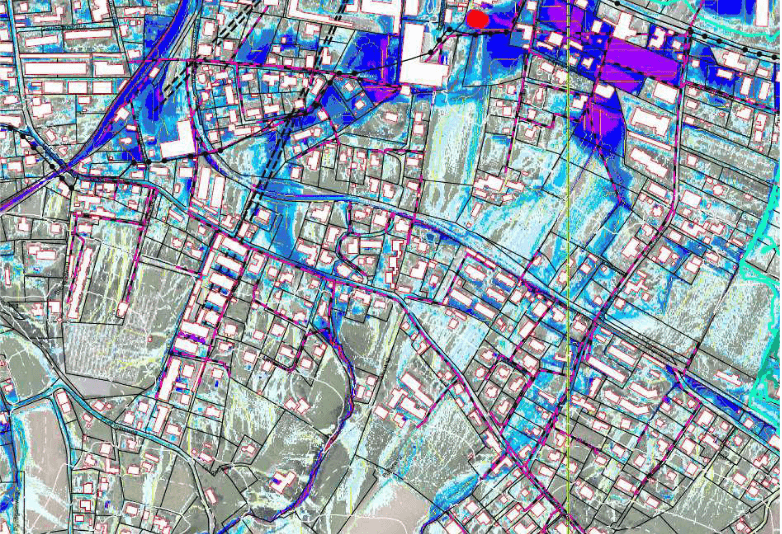 Stadtplan mit farbigen Markierungen, zeigt städtische Bereiche, Straßen und Gebäude, Fokus auf urbane Struktur.